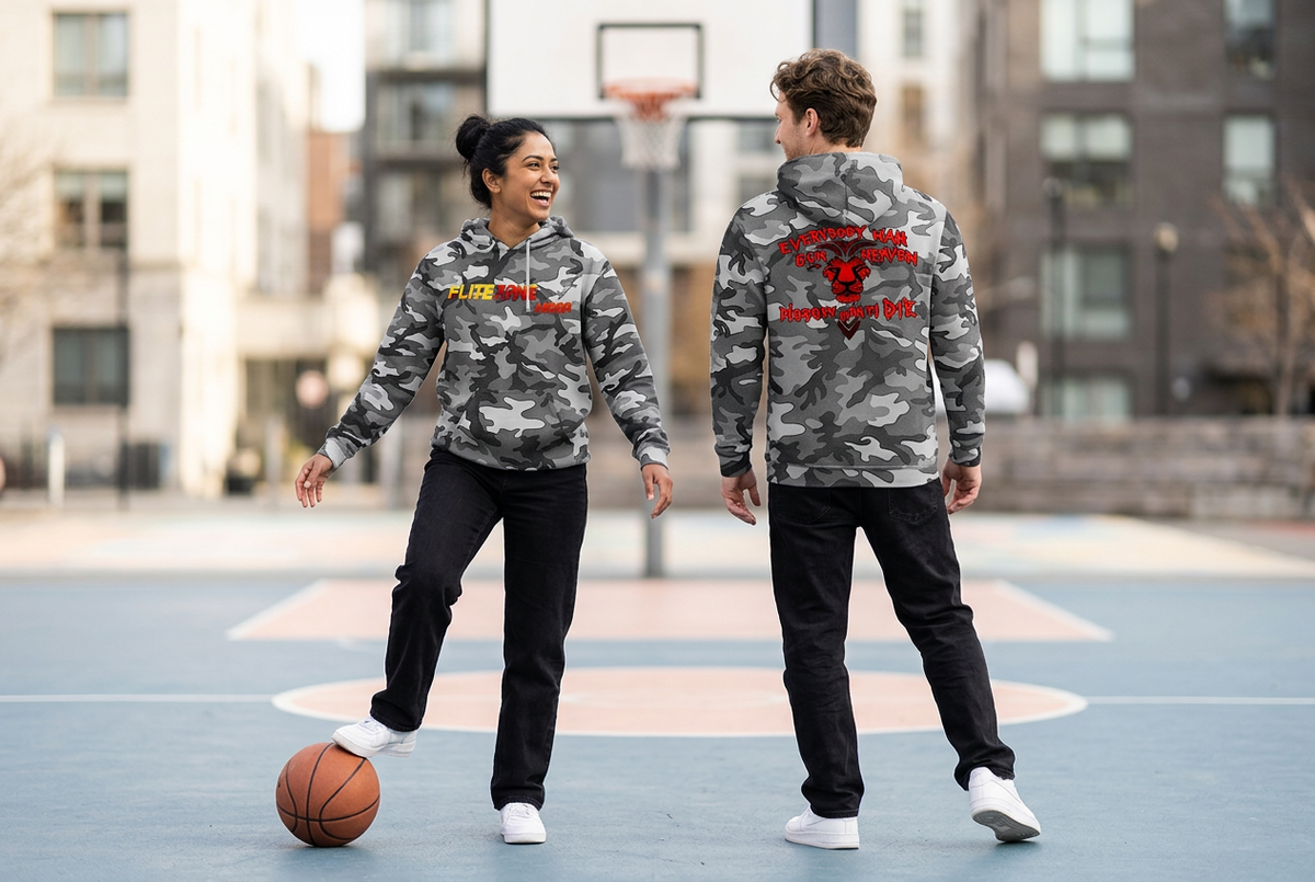 Playful basketball-court scene with a South Asian woman showing the gray-camo hoodie front and a white man showing the back