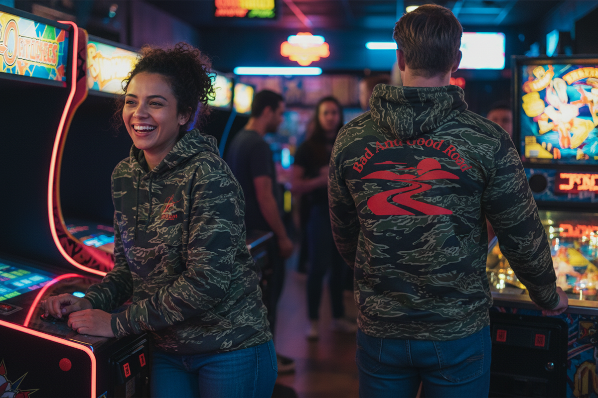 Two friends in a retro arcade with the hoodie front and back clearly visible
